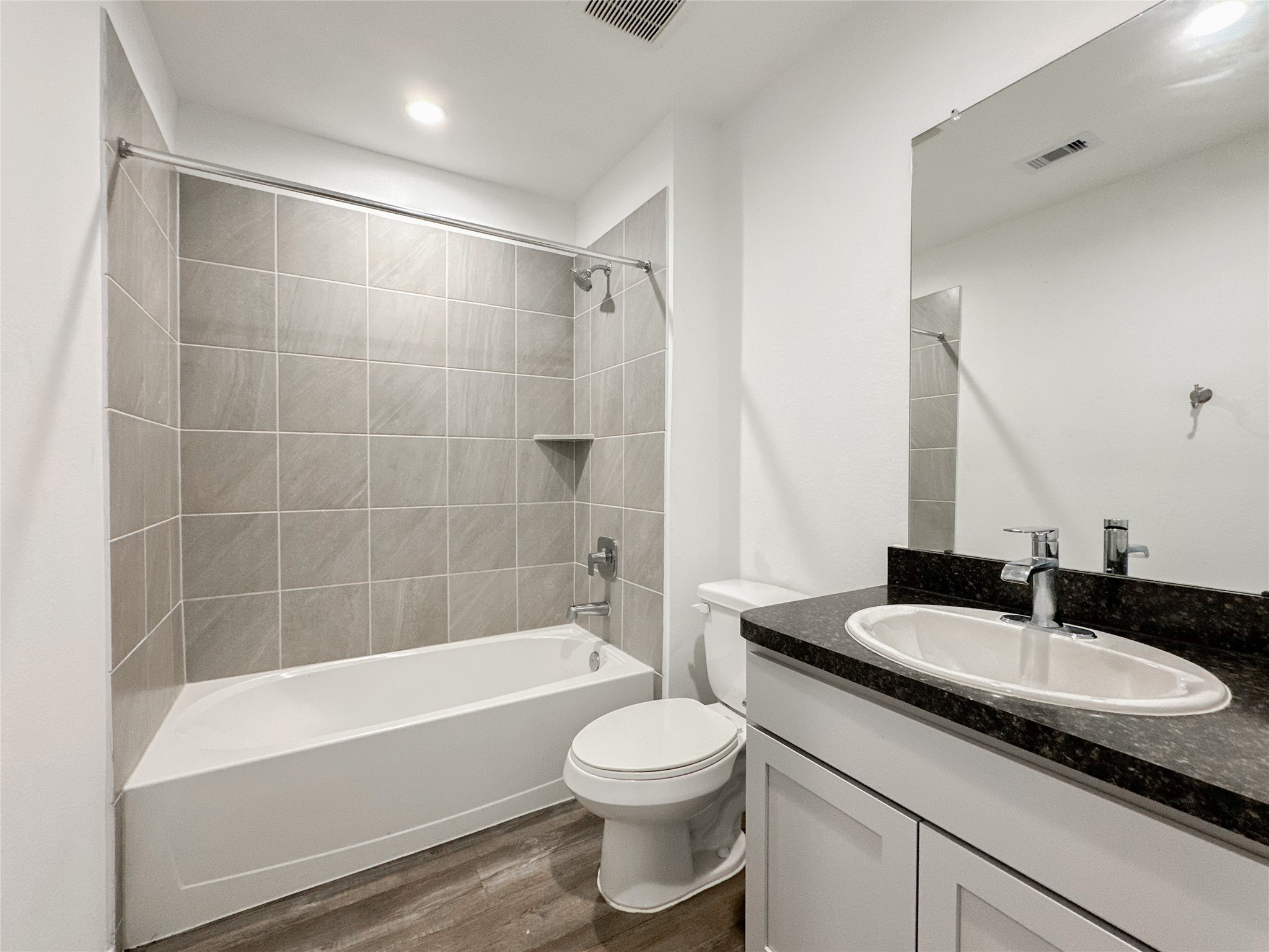 5715 Vintage Oakmont Drive Spring, TX 77373 - Photo 23 of 39 a bathroom with a granite countertop sink a toilet a mirror a bathtub and shower