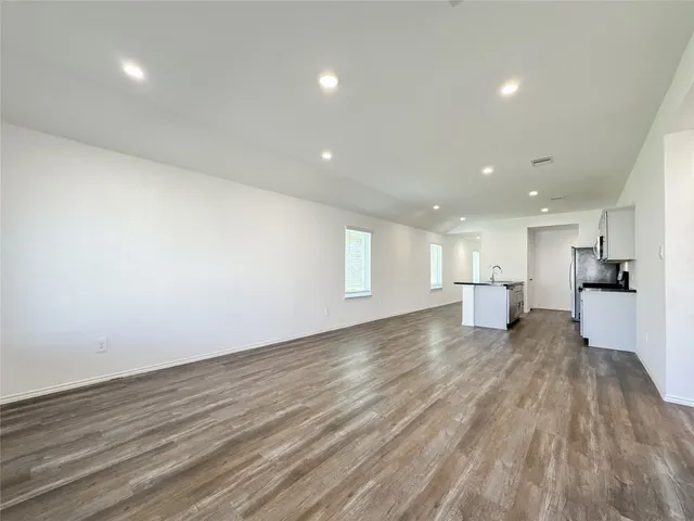 a view of a big room with wooden floor and a window