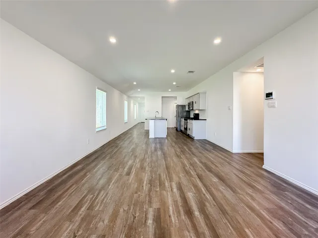 a view of empty room with wooden floor