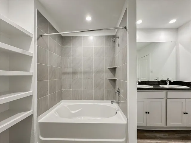 a bathroom with a granite countertop sink a toilet and bathtub