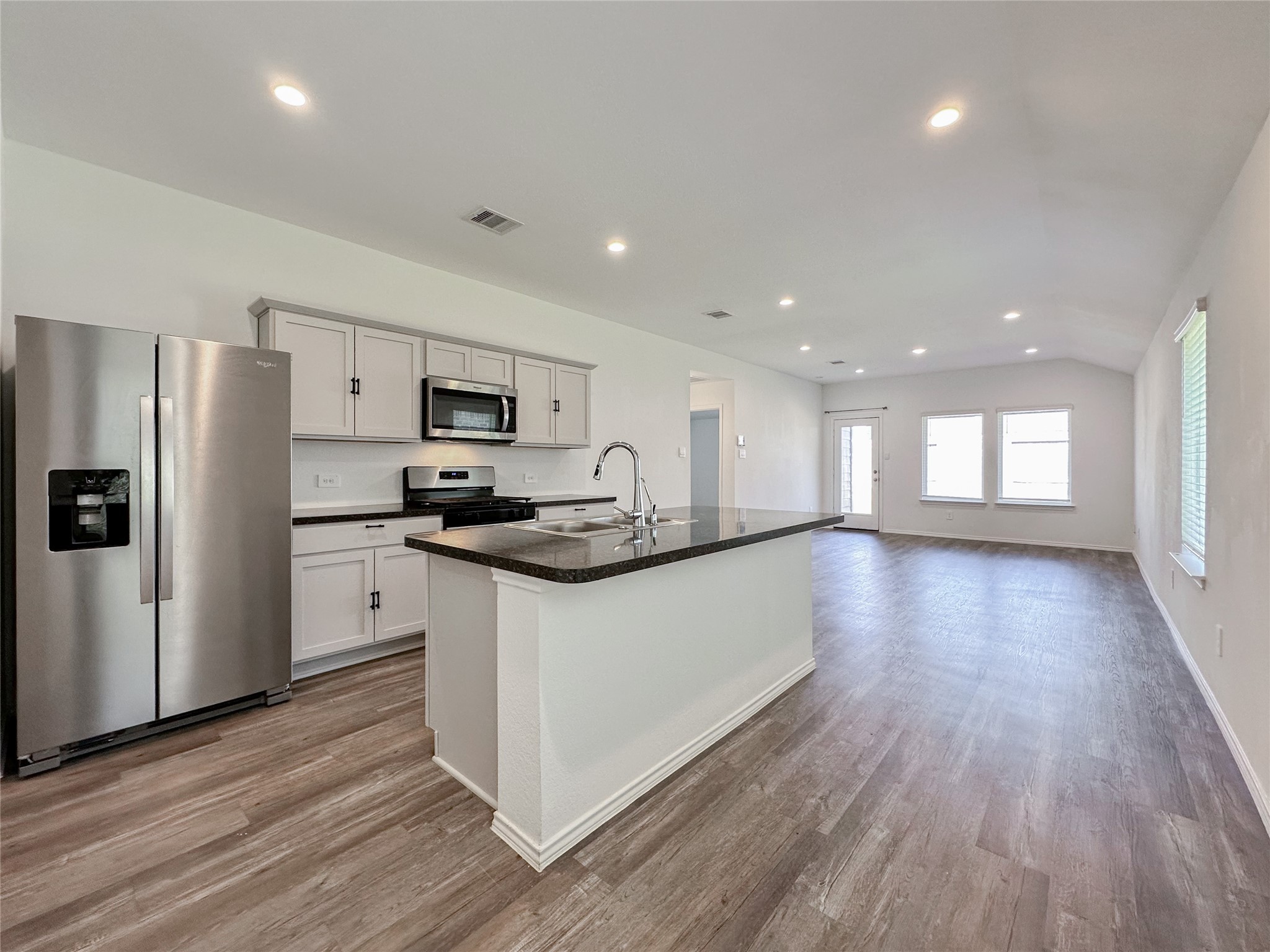 5715 Vintage Oakmont Drive Spring, TX 77373 - Photo 8 of 39 a kitchen with granite countertop a refrigerator a sink dishwasher a stove and white countertops with wooden floor