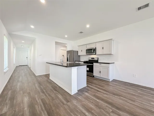 a kitchen with white cabinets and stainless steel appliances