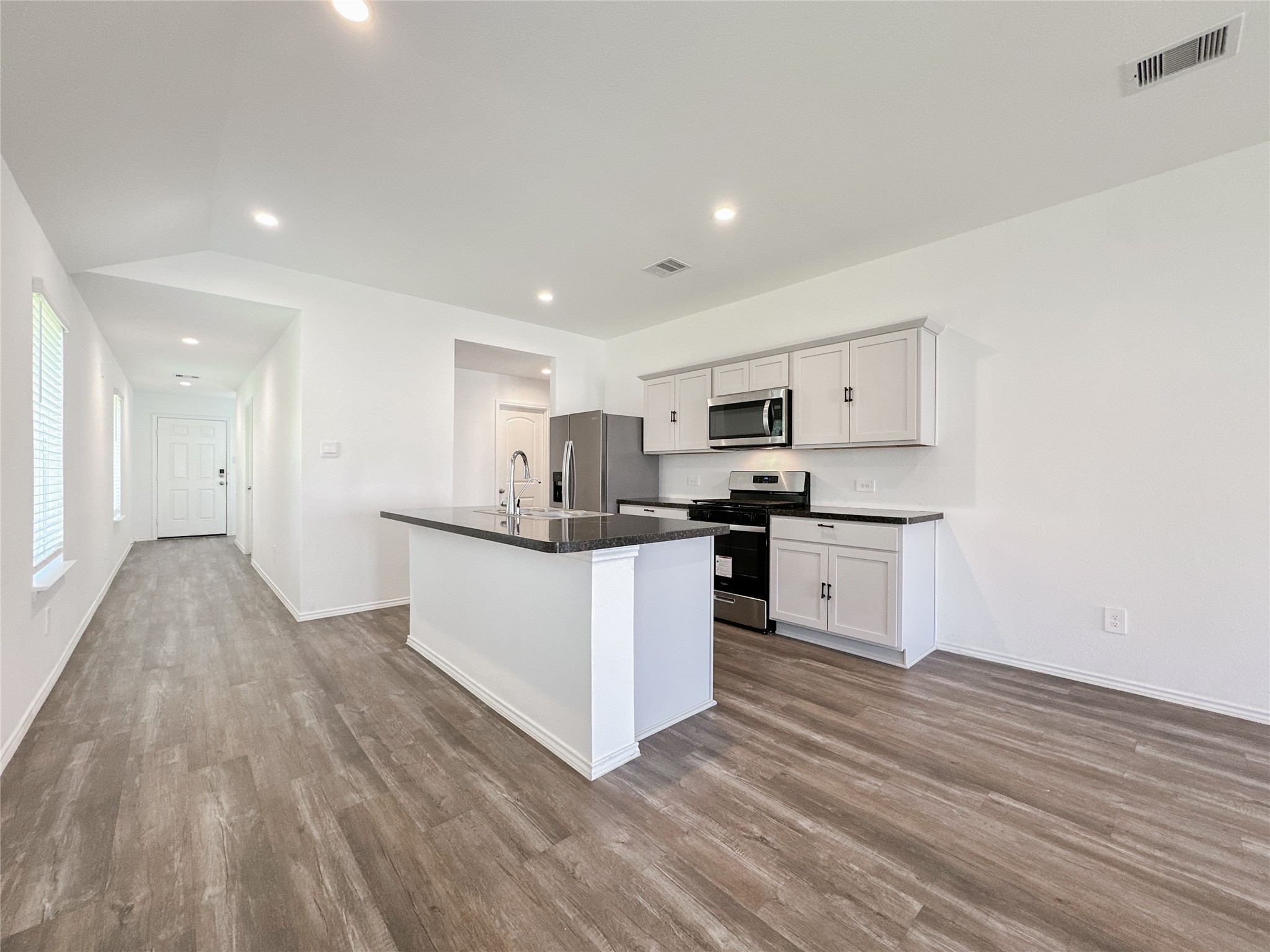 5715 Vintage Oakmont Drive Spring, TX 77373 - Photo 10 of 39 a kitchen with white cabinets and stainless steel appliances