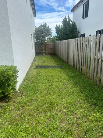 a view of a backyard with wooden fence