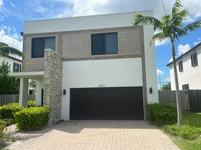 a front view of a house with plants