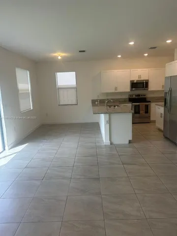 a kitchen with a sink a counter top space cabinets stainless steel appliances and a window