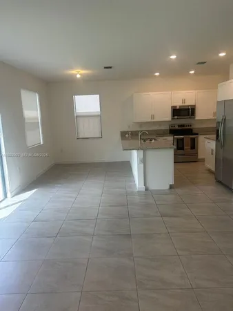 a kitchen with a sink a counter top space cabinets stainless steel appliances and a window