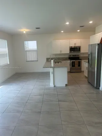 a kitchen with stainless steel appliances a refrigerator and a stove top oven