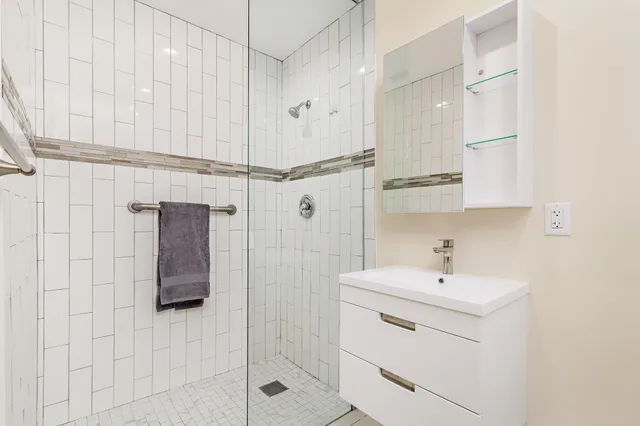 a bathroom with a shower sink and mirror