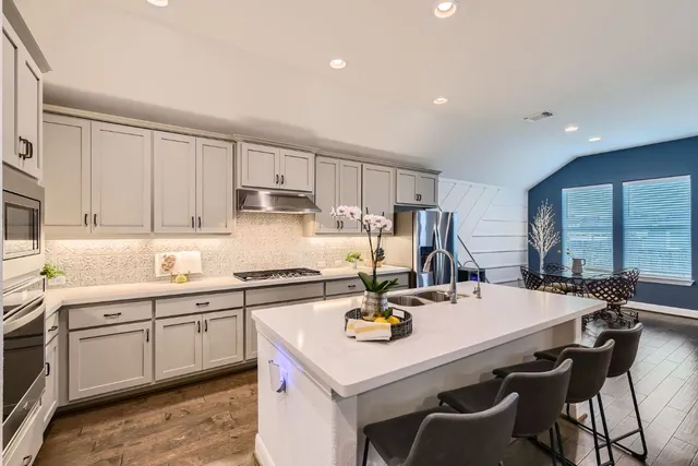 a kitchen with a sink a stove and chairs