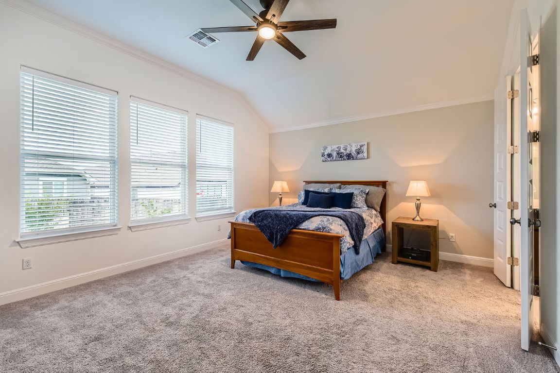 1332 Modoc Way Kyle, TX 78640 - Photo 14 of 28 Carpeted bedroom featuring ornamental molding, vaulted ceiling, and ceiling fan