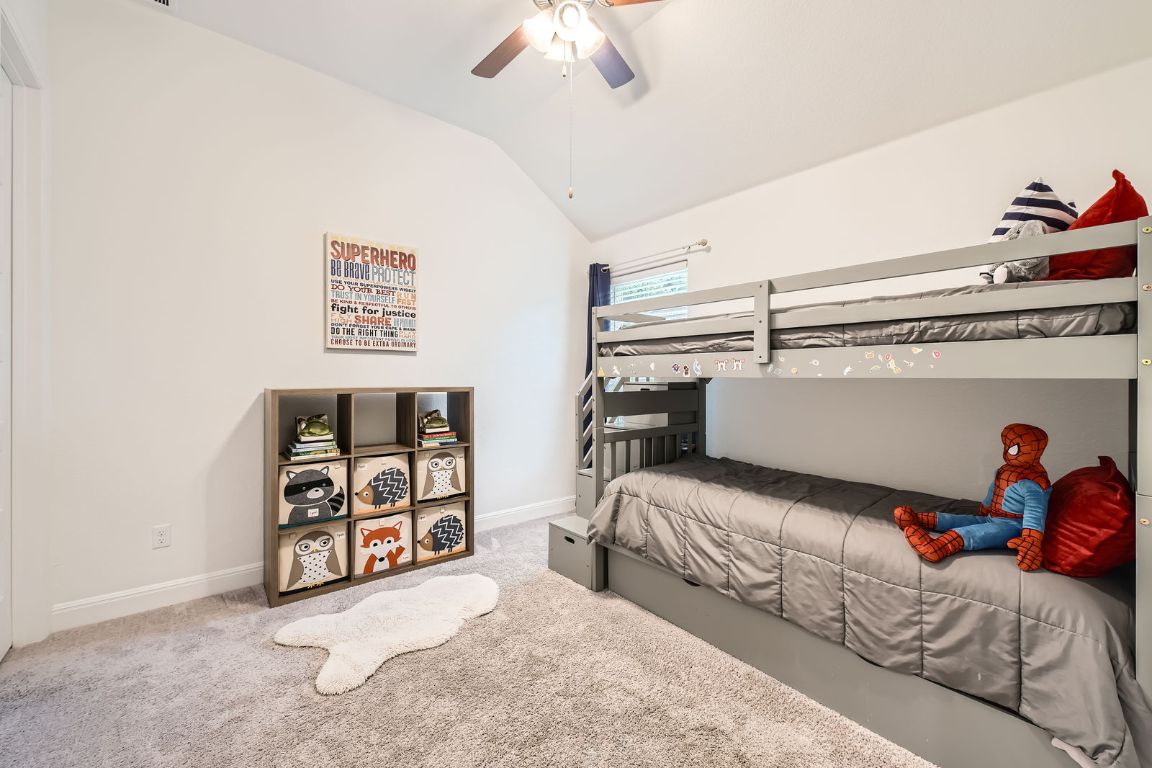 1332 Modoc Way Kyle, TX 78640 - Photo 20 of 28 Bedroom with lofted ceiling, carpet floors, and a ceiling fan