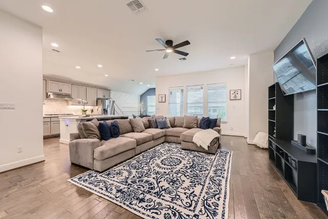 a living room with furniture a flat screen tv and kitchen view