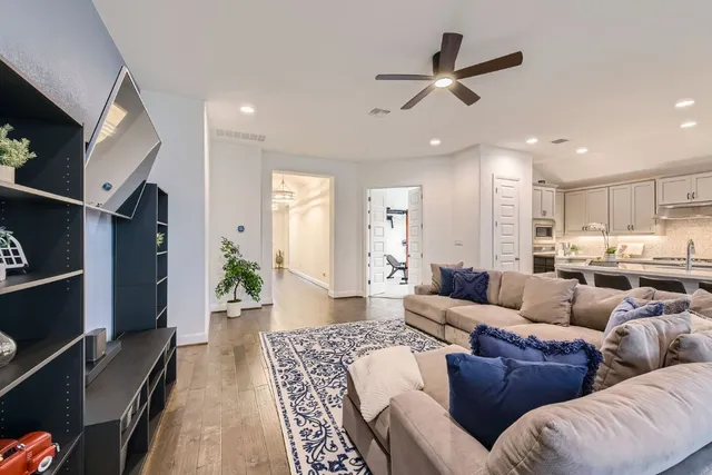 a living room with furniture kitchen view and a large window