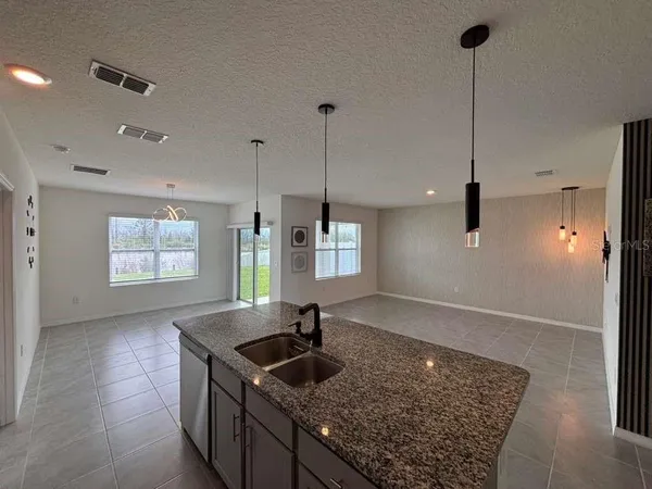 a kitchen with stainless steel appliances granite countertop a sink a window and wooden floor