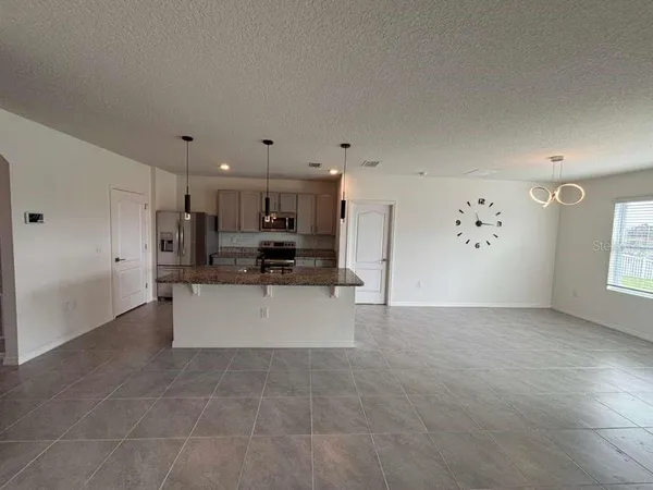 a large white kitchen with kitchen island a sink a stove and a refrigerator