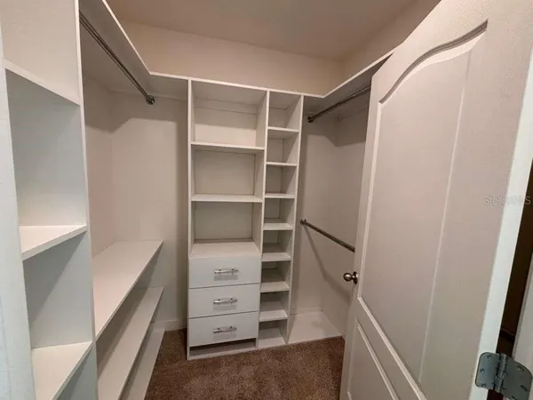 a view of walk in closet with empty racks