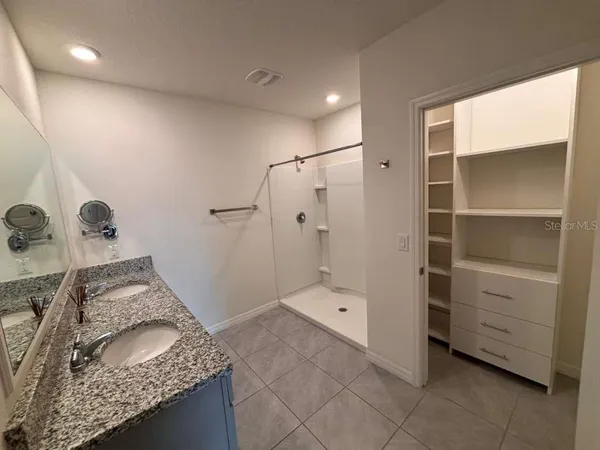 a bathroom with a granite countertop sink and shower