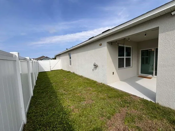 a backyard of a house with plants and wooden fence
