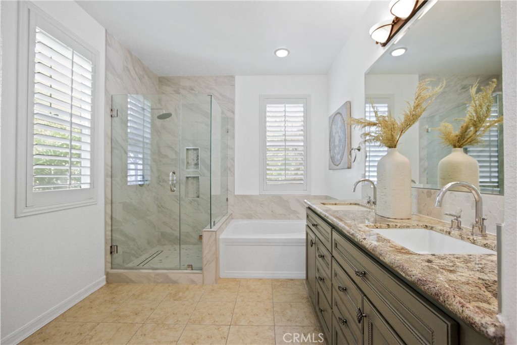 9 Paddock Place Ladera Ranch, CA 92694 - Photo 17 of 25 a bathroom with a granite countertop sink a toilet a mirror and shower