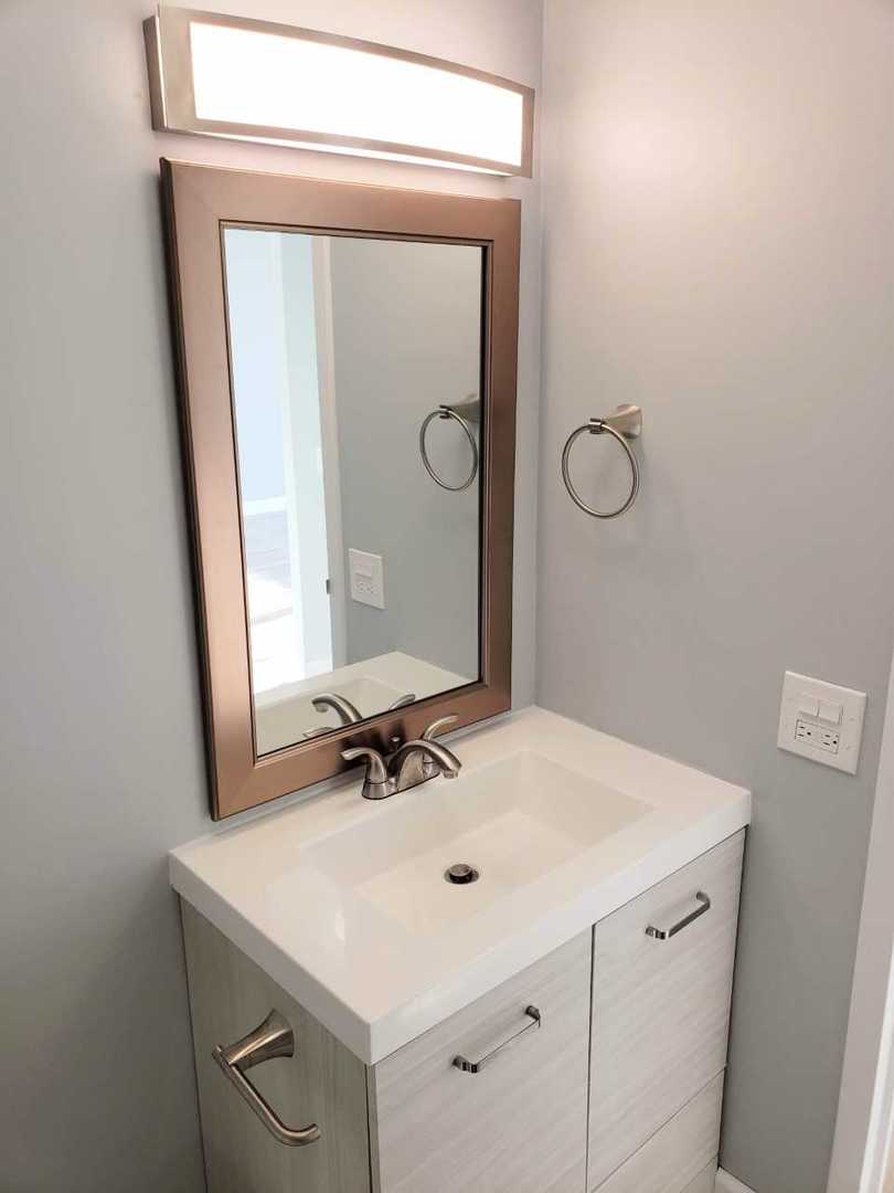 5445 North Sheridan Road, Unit 2005 Chicago, IL 60640 - Photo 17 of 19 a bathroom with a sink a vanity and a mirror