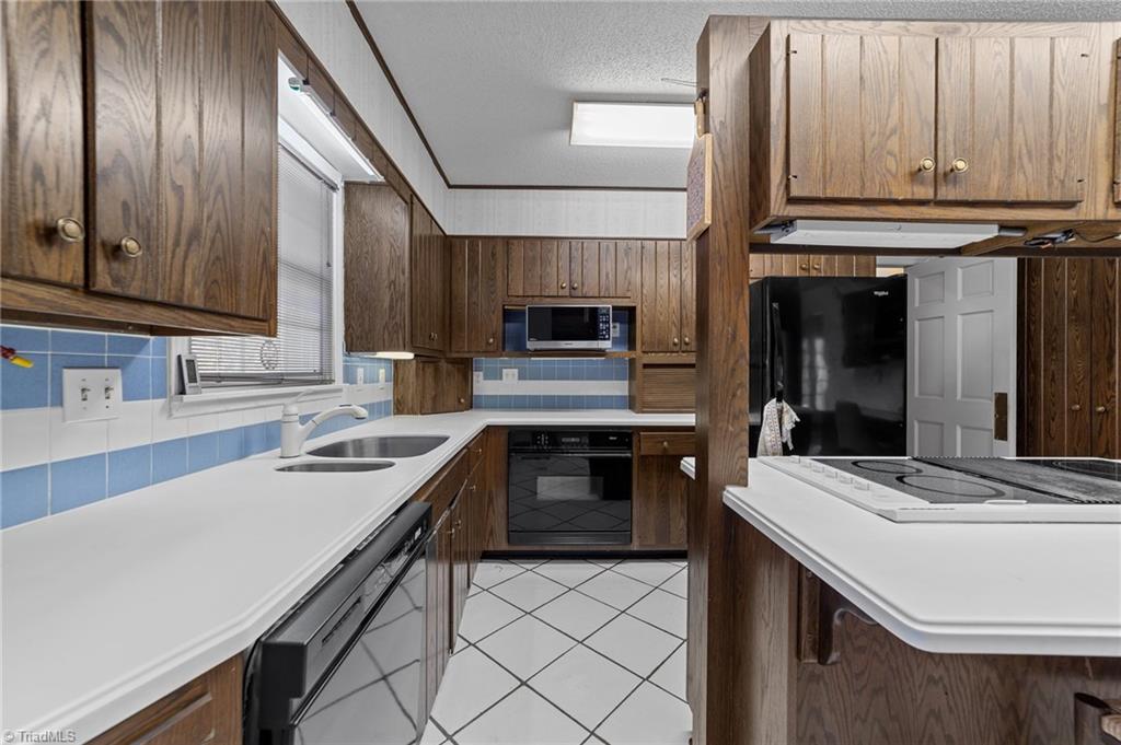 4532 Peeples Road Oak Ridge, NC 27310 - Photo 12 of 49 Kitchen with tile backsplash, lots of countertop space and appliances.