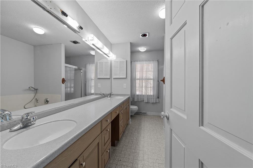 4532 Peeples Road Oak Ridge, NC 27310 - Photo 13 of 49 Ensuite bathroom with double vanity and separate shower & garden tub on the main floor.