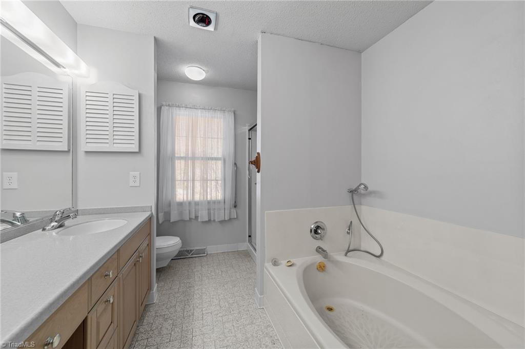 4532 Peeples Road Oak Ridge, NC 27310 - Photo 28 of 49 View of the garden tub and separate shower in the primary bathroom.