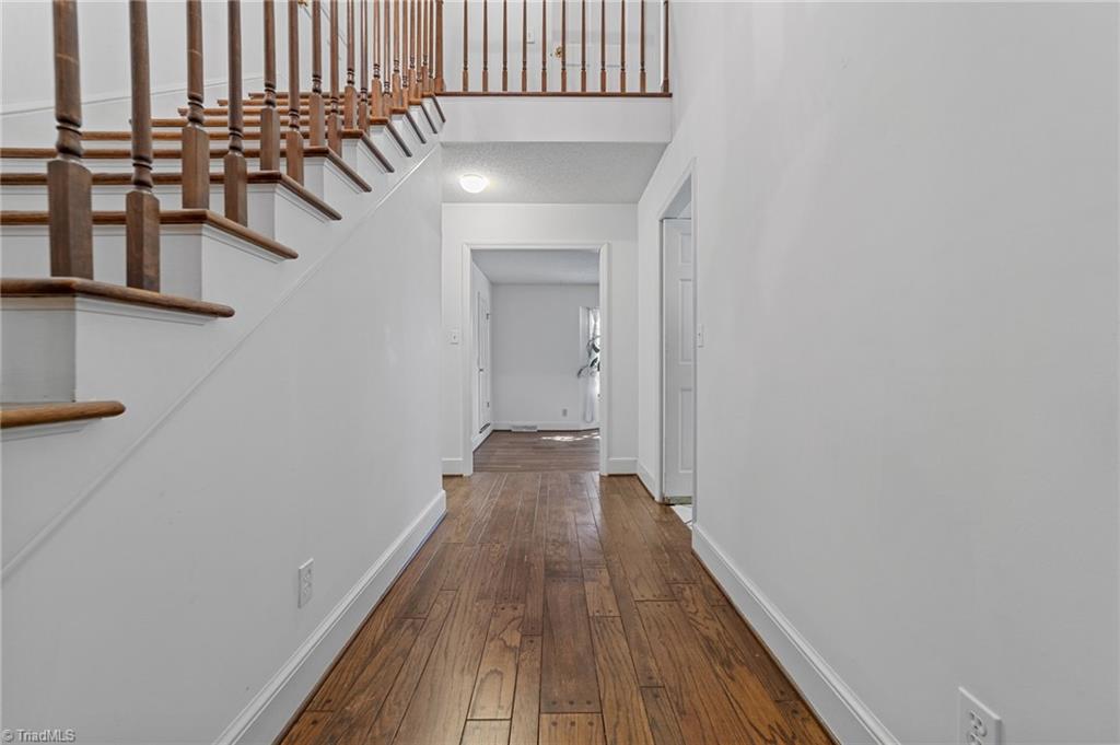 4532 Peeples Road Oak Ridge, NC 27310 - Photo 34 of 49 Hallway opens up to the living area with view of the stairs to the 2nd floor.