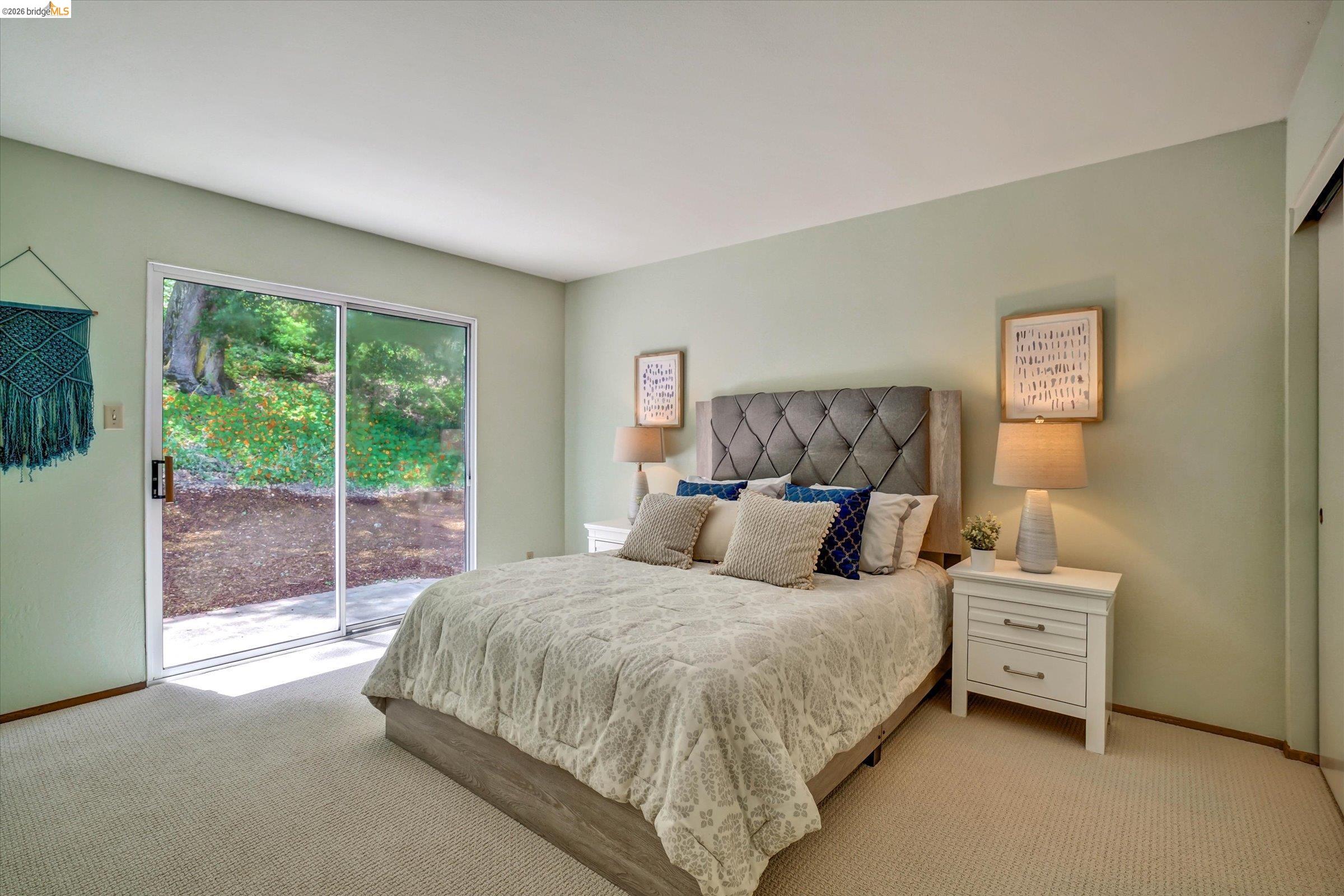 2826 Wright Avenue Pinole, CA 94564 - Photo 27 of 70 Sliding glass doors opening to outdoor space, light green wall color, plush carpet flooring, upholstered headboard, and built-in closet with sliding doors