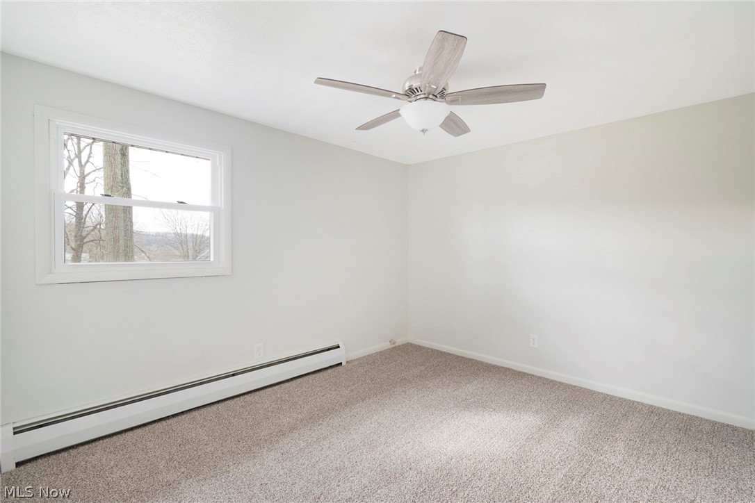 25005 West Egypt Road Minerva, OH 44657 - Photo 27 of 33 Carpeted bedroom with ceiling fan and a baseboard heating unit