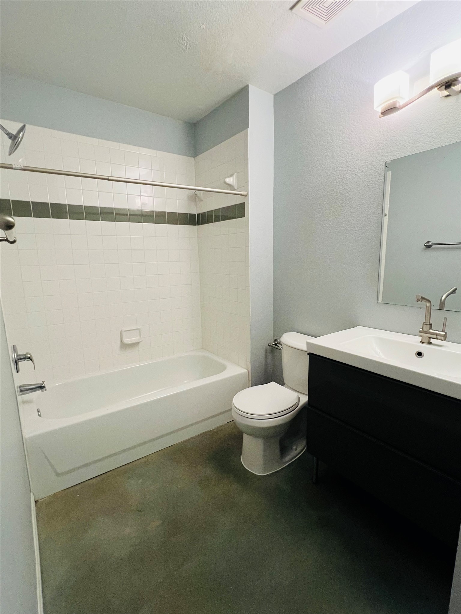 2409 Santa Rosa Street Austin, TX 78702 - Photo 17 of 27 A modern vanity with clean lines highlights this practical bathroom containing a tiled shower-tub combination.