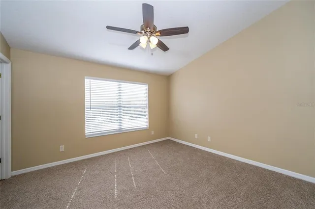 an empty room with a window and a fan