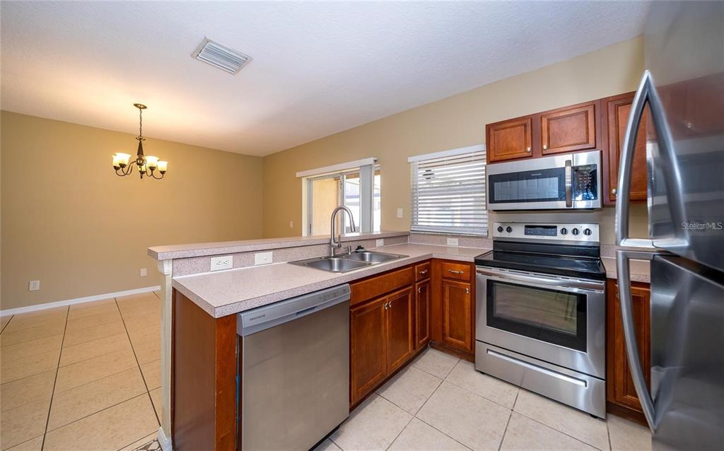 1238 Beckenham Way Wesley Chapel, FL 33543 - Photo 2 of 31 a kitchen with a sink stove and microwave