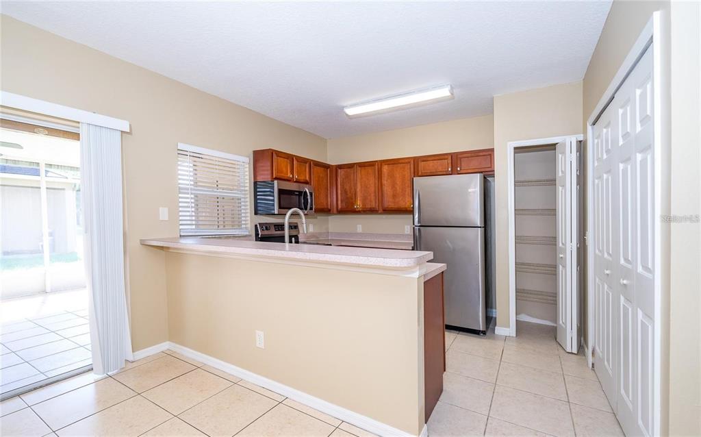 1238 Beckenham Way Wesley Chapel, FL 33543 - Photo 10 of 31 a kitchen with stainless steel appliances granite countertop a refrigerator and a sink