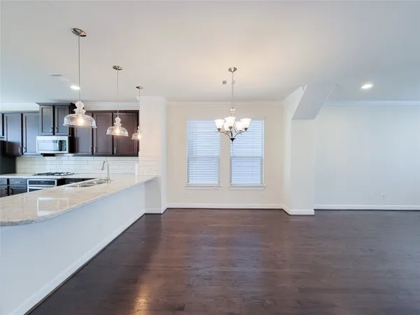 a large kitchen with granite countertop a large counter top a sink stainless steel appliances and cabinets