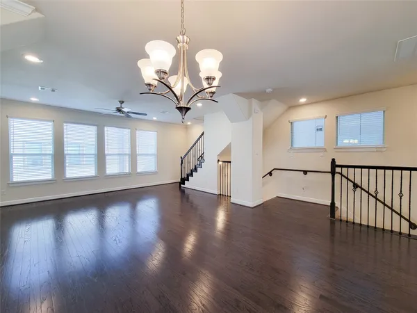 a view of a livingroom with wooden floor and a ceiling fan