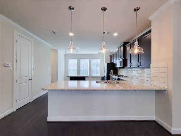 a large kitchen with kitchen island a sink stainless steel appliances and a chandelier