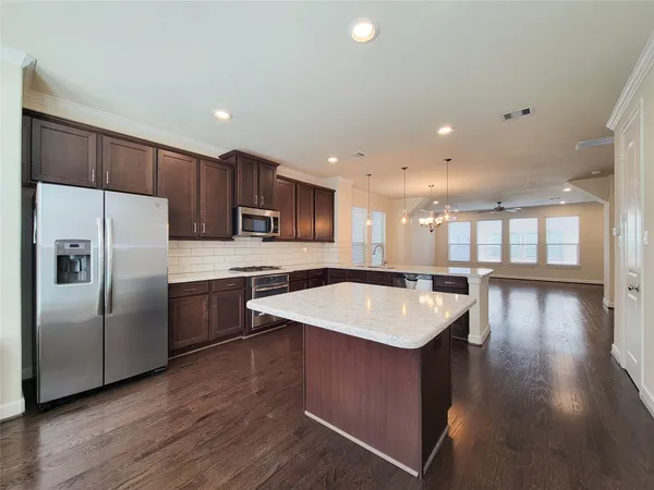 a kitchen with a sink a refrigerator and wooden floor