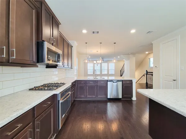 a kitchen with stainless steel appliances granite countertop a stove and cabinets