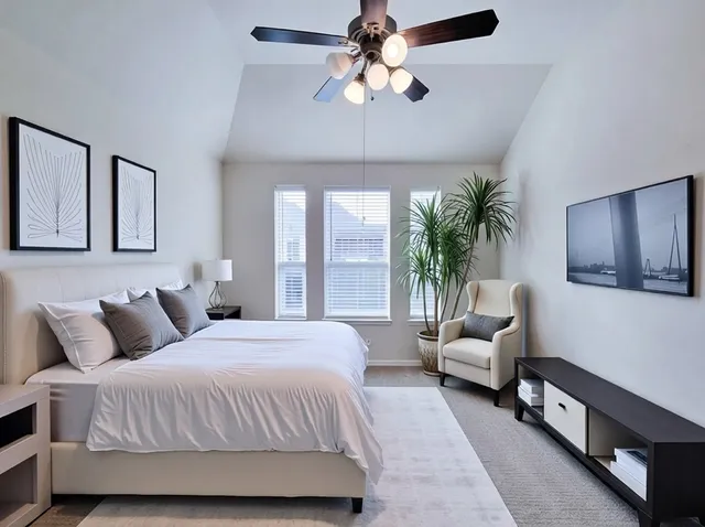 a bedroom with a large bed couch and a window