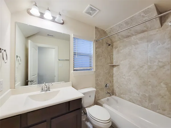 a bathroom with a sink a toilet a mirror and shower