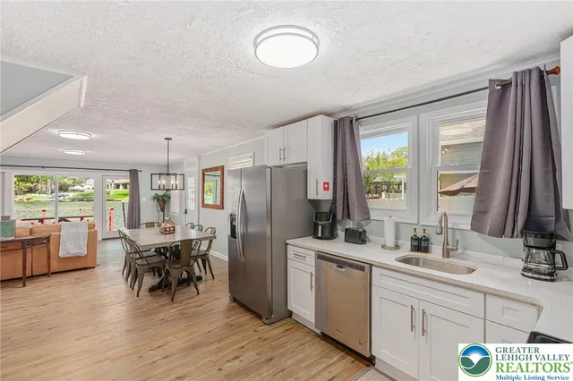 a kitchen with a sink appliances dining table and chairs