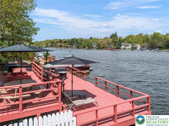 a view of a roof deck with table and chairs a barbeque