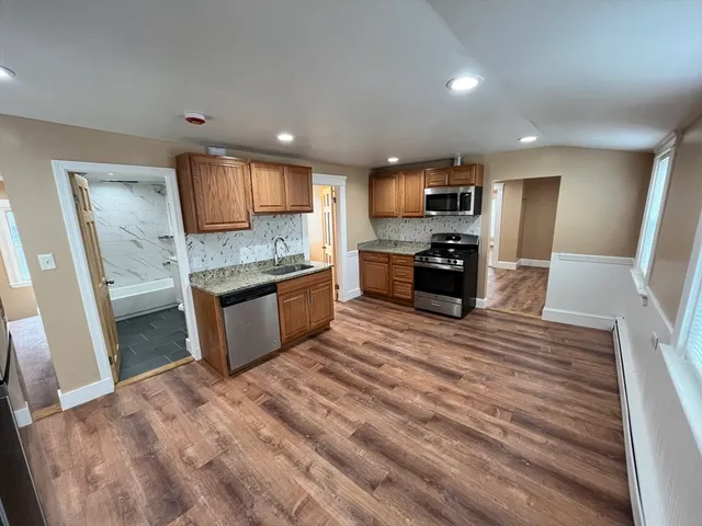 a kitchen with stainless steel appliances granite countertop a stove sink and cabinets