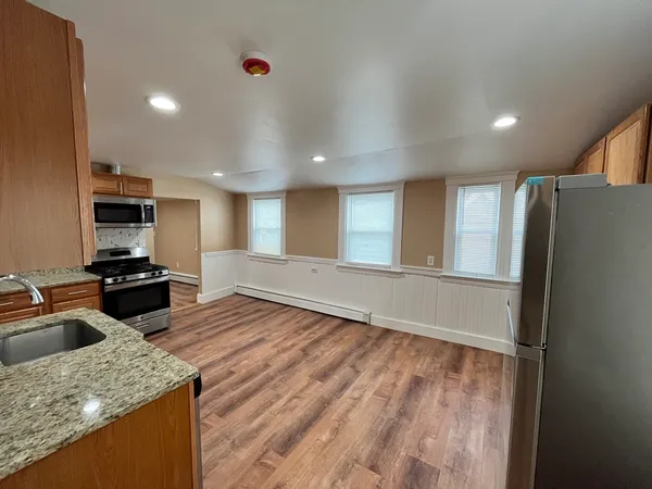 a kitchen with stainless steel appliances granite countertop a refrigerator and a sink