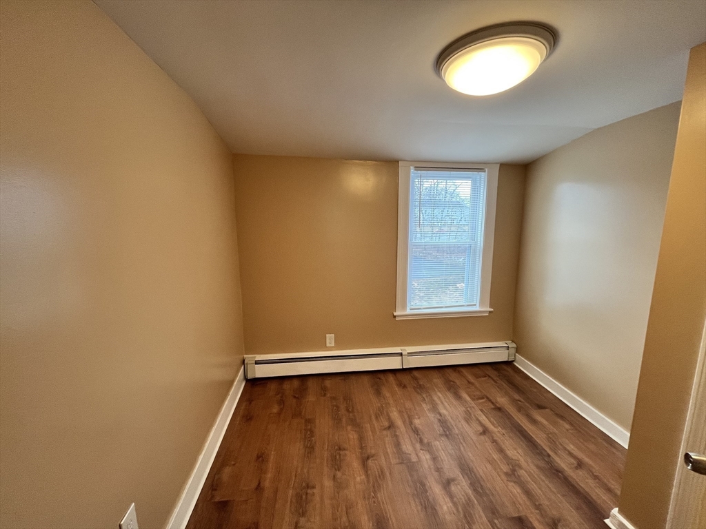 11 Benefit Terrace, Unit 3 Worcester, MA 01610 - Photo 10 of 15 an empty room with wooden floor and windows