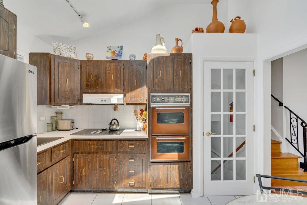233 Amherst Avenue Colonia, NJ 07067 - Photo 29 of 56 a kitchen with a refrigerator a stove and wooden cabinets