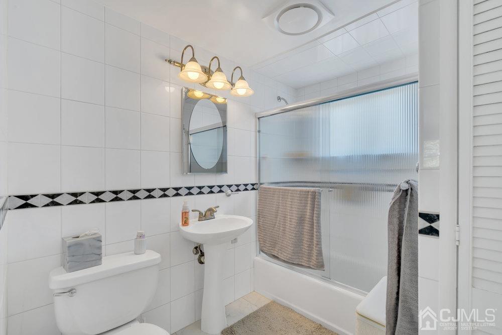 233 Amherst Avenue Colonia, NJ 07067 - Photo 34 of 56 a bathroom with a shower a mirror and a sink