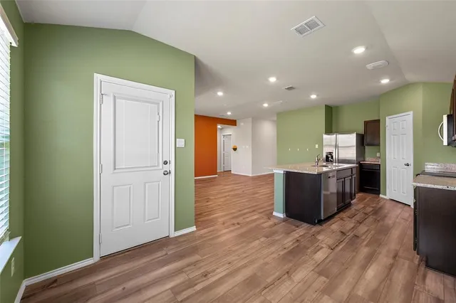 a kitchen with stainless steel appliances kitchen island wooden cabinets and granite counter tops
